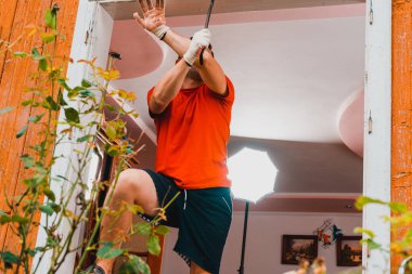 Bir işçi, evdeki eski bir pencereyi levyeyle söker. 2020.