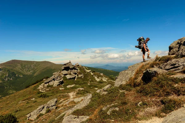 山頂にはリュックを背負った若者が立っており カルパチア山脈の頂上からの景色を楽しむことができます — ストック写真