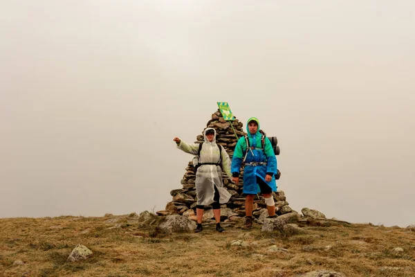 山の上にはレインコートを着た観光客 ブレベンスクール山と霧 モンテネグロの尾根の雨雲 幸せな観光客が立っています 2020 — ストック写真