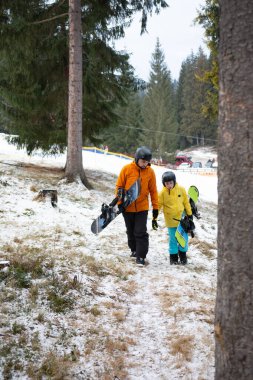 Karla kaplı bir arazide, etrafını saran uzun ağaçlar ve dağlarda bir kış günü havada bir nebze de olsa heyecan taşıyan iki kişi yürür..