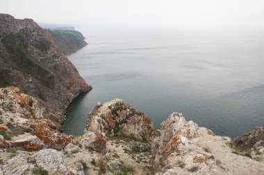Bir yüksek kayalık sahil uçurumdan denizin bir göl ve sis su üzerinde