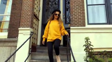 Genç kız inanılmaz sarı kazaklı, şapka, Amsterdam'da güneş gözlüğü takıyor. Yürüme, gülümseyen turist. Kiralık ev kızı bırakır, hava Parlatıcı, o gülümsüyor. Şehri görmek için gider.