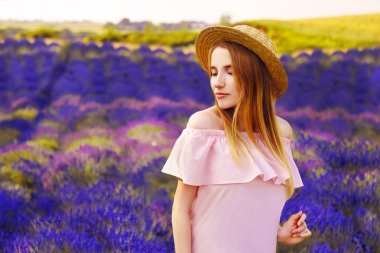 Lavanta alan güzel kız. Günbatımı lavanta alanında güzel bir kadın. Yumuşak odak. Provence, Fransa. Bir kız pembe elbise ve şapka yürüyen yalak lavanta alanları ve doğa sever.