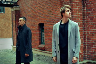 Genç yakışıklı kat mans. Gri şık ceket poz moda iyi giyimli adam portresi. Kendinden emin ve odaklanmış çocuklar. Mükemmel saç modeli olan zarif adam. Erkek saç şekillendirme.