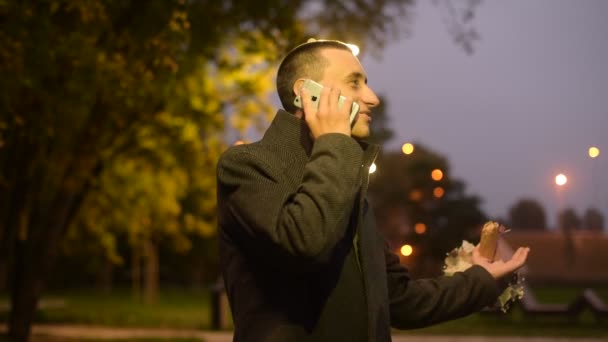 Man Met Bloemen Het Park Herfst Belt Zijn Vriendin Voor — Stockvideo