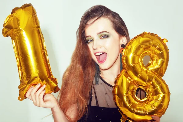 18. yaş gününde altın numaralı balonlarla doğum günü kızı. Heyecanlı 18 yaşında yeşil makyajlı ve siyah elbiseli bir kız. Mankenlik yapıp eğleniyoruz. Mutlu yıllar sana, tatlı kız..