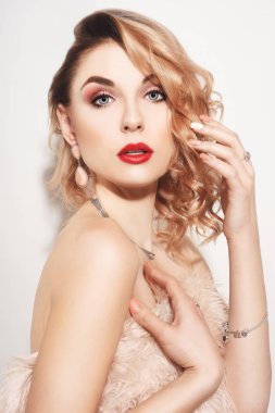 Küpeli ve yüzüklü güzel bir kadın. Mücevher ve elmas modelleri. Mücevherli genç bir kızın moda portresi. Cerly air ve kırmızı dudaklı sarışın kız. Mükemmel bir makyaj. Pembe ceketli kız.
