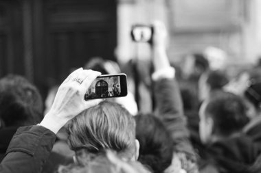 Bir star için bekliyorlar. Kalabalık bir yıldız telefonda vuruyor. Her yerde paparazzi. Gazeteciler otel yakınındaki bir star için bekliyor