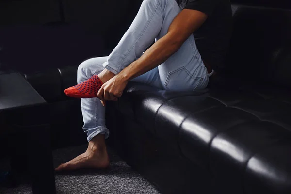 man red socks. Close up of a man wearing colorful sock. Man at home.