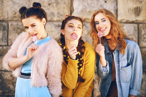 Drei Schöne Mädchen Models Essen Lutscher Freundinnen Mit Unterschiedlichen Frisuren — Stockfoto