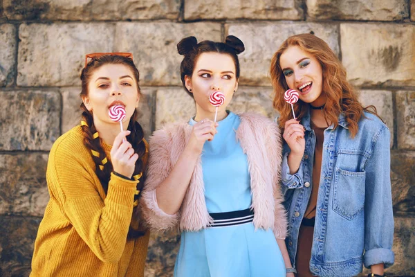 Drei Schöne Mädchen Models Essen Lutscher Freundinnen Mit Unterschiedlichen Frisuren — Stockfoto