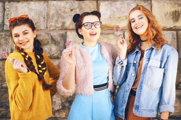 Drei Schöne Mädchen Models Essen Lutscher Freundinnen Mit Unterschiedlichen Frisuren — Stockfoto