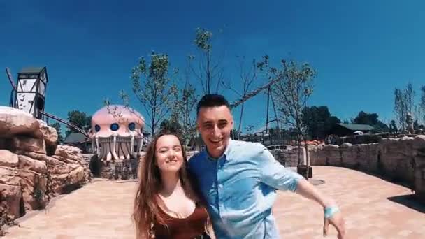 Couple Walks Amusement Park Girl Guy Jump Rejoice Background Slides — Stock Video