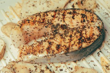 Somon fotoğrafı. Taze kırmızı balık zengin renk. Izgarada mantar ve tavuk filetosu. baharat, kurutulmuş fesleğen, tuz, biber. Somon inon elektrikli ızgara fesleğen marine. Tarifi. 