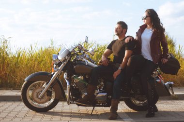 Alan arka planda çift motosiklet yakınında duruyor