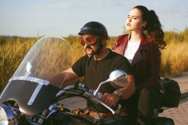 Birkaç bisikletciler saha üzerinden binerler. Bir adam Motorcycl sürücü