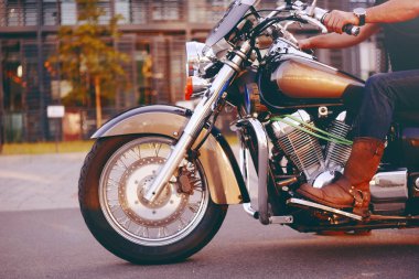Biker Motosiklete biniyor. Deri bacaklar alt görünümü