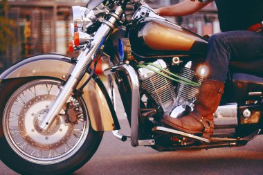 Biker Motosiklete biniyor. Deri bacaklar alt görünümü