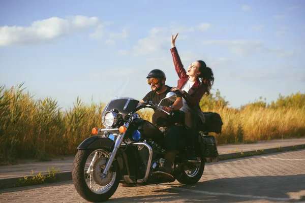 The girl rolls her boyfriend on a motorcycle. Girl is driving a Stock Photo MoreThanProduction 283825906