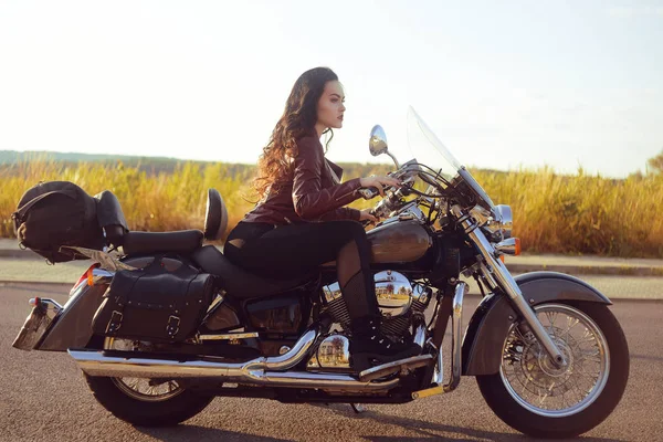 Belle brune dans une veste en cuir rouge sur une moto en th — Photo