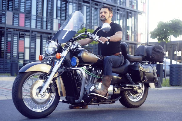 A man on a motorcycle near the office. Man on a motorcycle takes