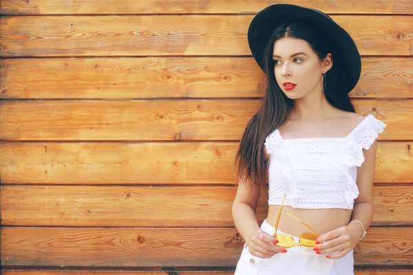 Ragazza alla moda in un cappello e occhiali. Bruna in un abito bianco — Foto Stock