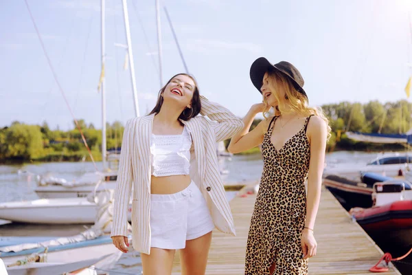 Две девушки на фоне яхт, плывущих лодок улыбаются, л — стоковое фото