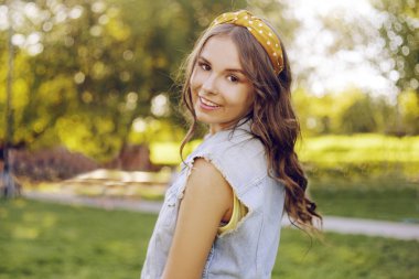 Güzel kahverengi saçlı kadın kameraya bakıyor. Genç bir kız.