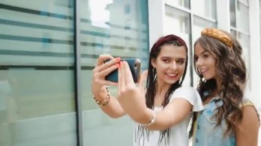 İki kız arkadaş / kız kardeş yeni binaların, ofislerin ve şehrin etrafında yürüyor. Kızlar eğlenir, yürür, güler, zıplar. Turistler yürür ve güler. Seyahat ediyorum. Telefonda selfie çekiyoruz.