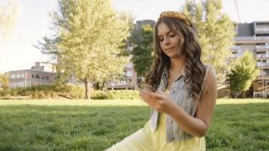 Bir kız parkta oturur, mesaj yazar, arar. Esmer, telefonda, parkta, aylak aylak dolaşıyor, kız arkadaşını / erkek arkadaşını arıyor. Telefonda konuşurken, kız gülümsüyor..