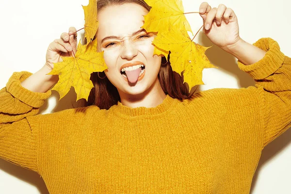 Una chica en un suéter amarillo de otoño y deja los árboles va craz — Foto de Stock