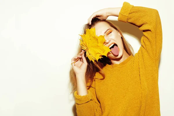 Una chica en un suéter amarillo de otoño y deja los árboles va craz —  Fotos de Stock