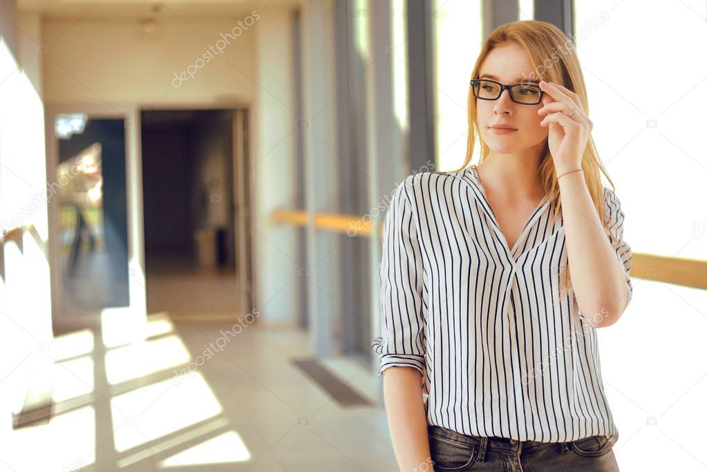 Young blonde student girl looking at camera. Woman in sunglasses