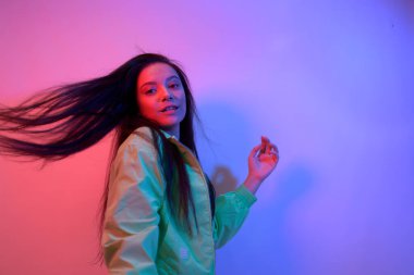 Esmer olan neon ile dans ediyor, kırmızı-mavi dansçı. Hip hop kızı, parti, gülümseme.