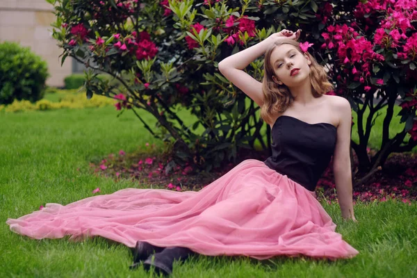 Una Niña Vestido Largo Rosa Sienta Jardín Sobre Hierba Sobre —  Fotos de Stock