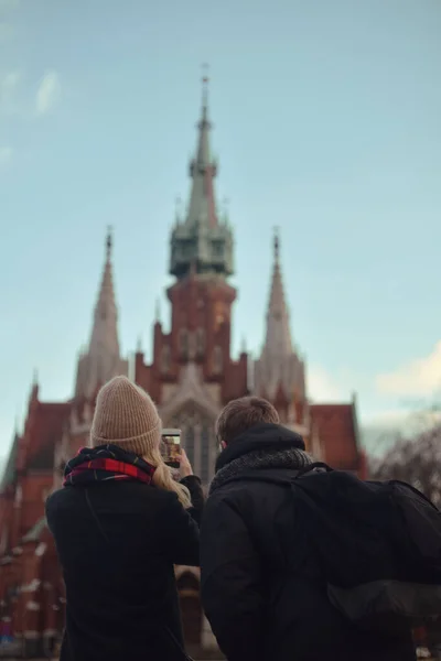 一对夫妇去克拉科夫 在电话上拍照 寒冷的季节 夫妇俩为历史名城的教堂拍照 — 图库照片