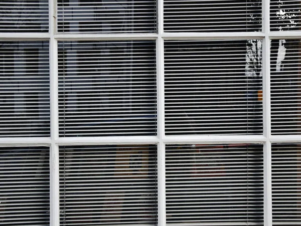 White shutters behind white windows. Simple style of old buildings