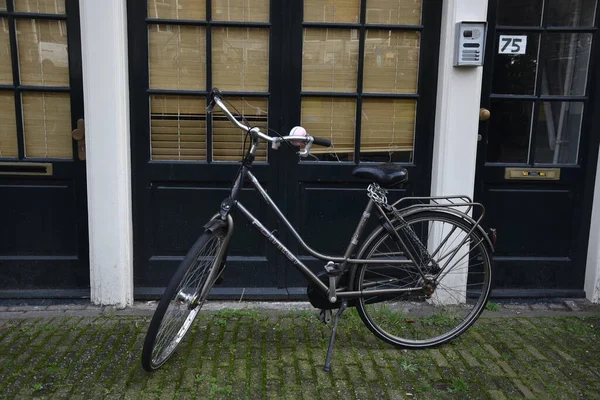 Bicycle near a typical building in Amsterdam. Amsterdam mode of transport