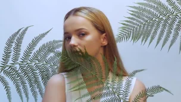 Krásná Dívka Tropických Listech Studiu Dotýká Její Tváře Konceptu Přírodní — Stock video
