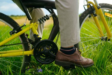 Erkek ayakları pedallarda, bisiklette, dağda. Tekerlek
