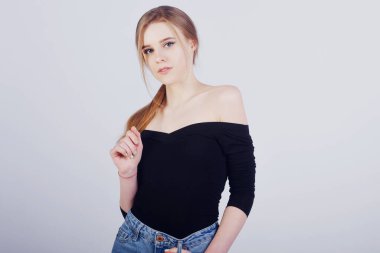 Güzel sarışın kız beyaz arka planda poz veriyor.