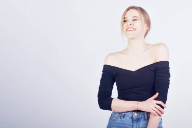 Beyaz arka planda gülümseyen sarışın öğrenci. Metin veya ürün için boş boşluk.