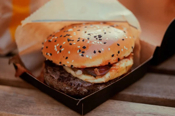 Hambúrguer Carne Suculento Está Pacote Preto Uma Mesa Madeira Comida — Fotografia de Stock