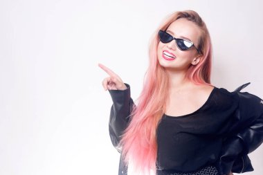 Gözlüklü ve siyah elbiseli pembe saçlı bir kız mesaj ya da ürün için boş bir yer gösteriyor. Kara Cuma. Gülümseyen kadın