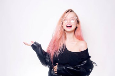 Gözlüklü ve siyah elbiseli pembe saçlı bir kız mesaj ya da ürün için boş bir yer gösteriyor. Kara Cuma. Gülümseyen kadın