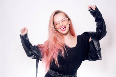 Gözlüklü ve siyah elbiseli pembe saçlı bir kız mesaj ya da ürün için boş bir yer gösteriyor. Kara Cuma. Dans eden kadın