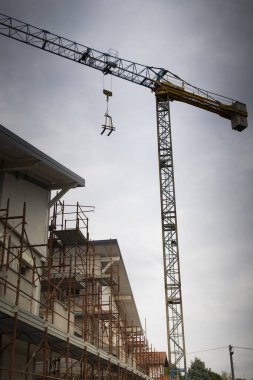 gri gökyüzü ile bir konut inşaatı sitedeki vinçler. Dikey vurdu.
