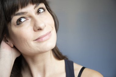 Genç kadın yakın çekim portre. Beyaz uzun kumral ve patlama ile. Gülümseyen ifade, boyun arkasında bir eliyle hemen arıyorum. Kopya alanı.