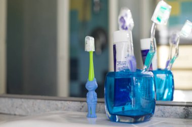 Banyoda iki normal olanlar ve bir hayvan şekilli çocuk diş fırçası ile aile diş fırçaları