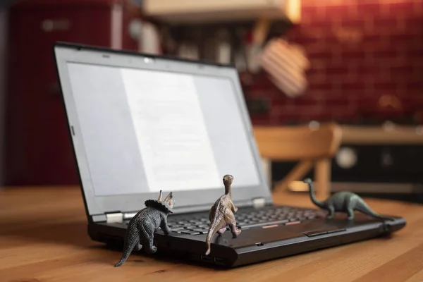 Open Laptop Wooden Table Small Dinosaur Toys Seem Looking Screen — Stock Photo, Image